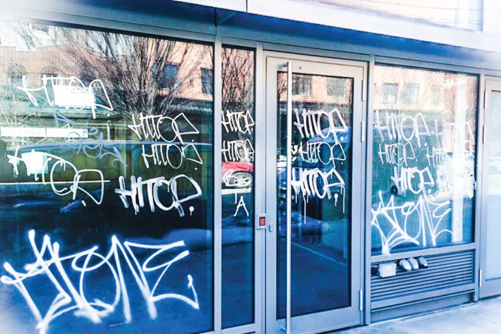 A shop front in the USA with graffiti on the glass that has anti-graffiti window film